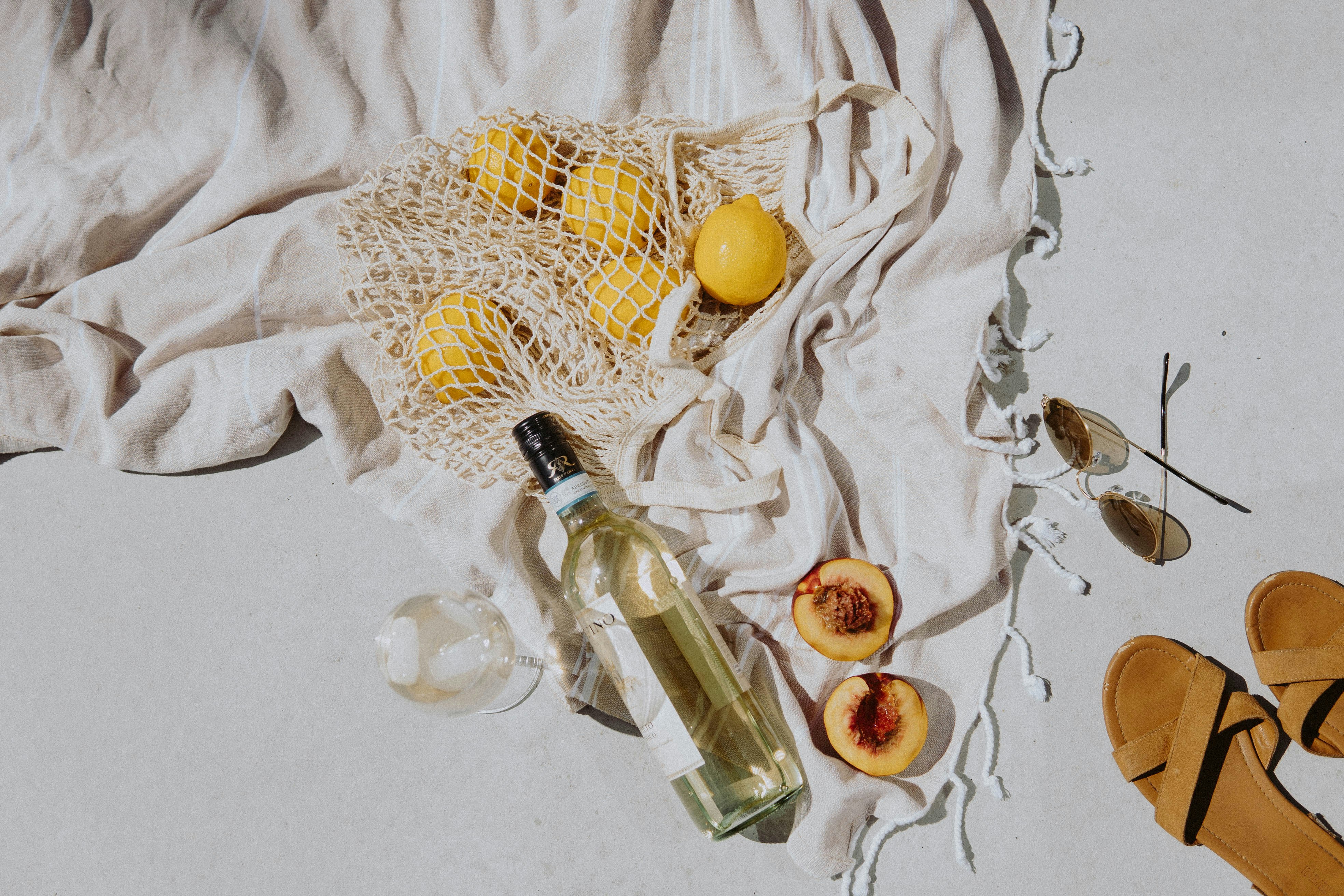 clear glass bottle with yellow round fruit on white textile